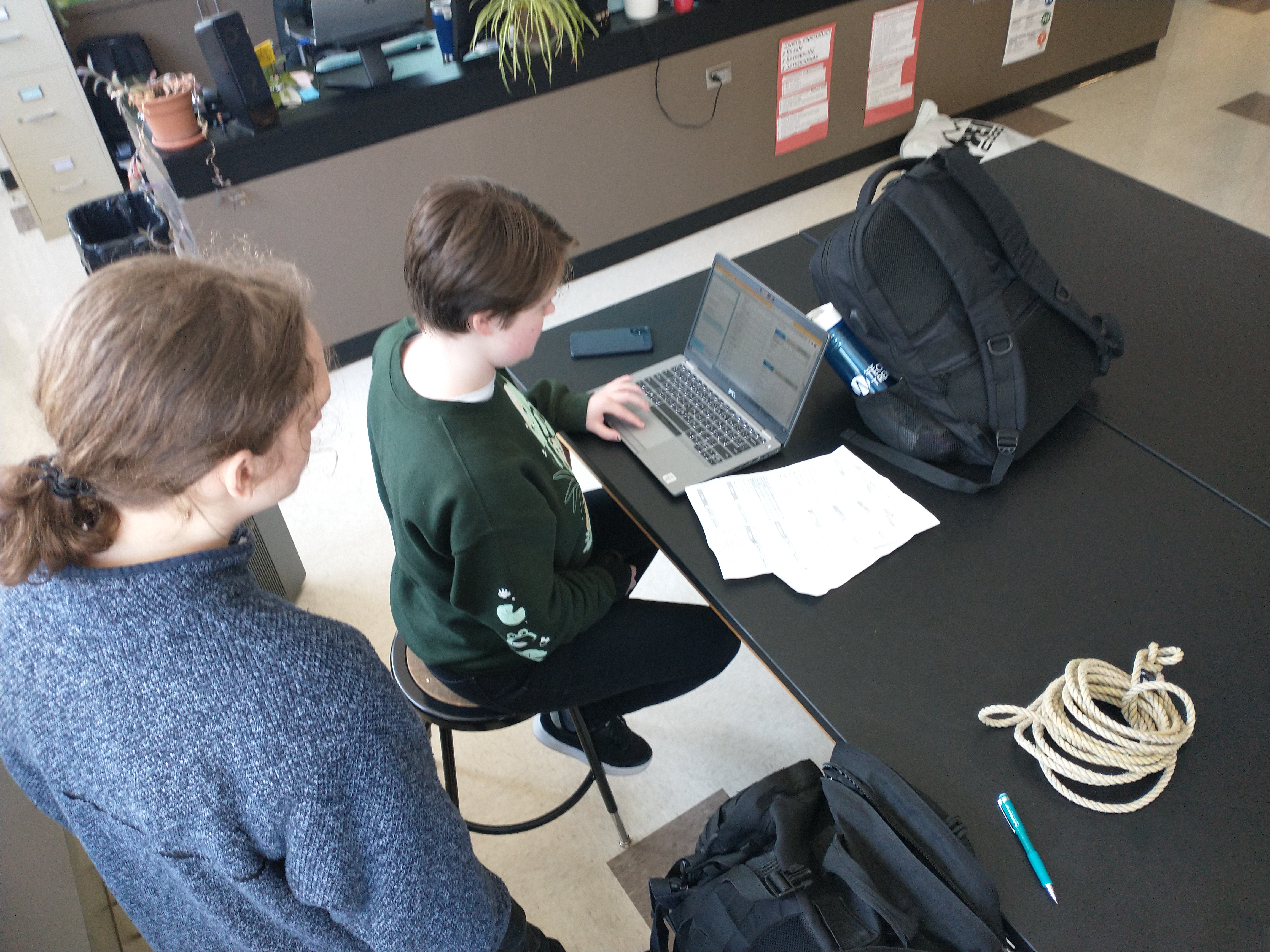 Two students sit at a lab table entering data into the MDMAP database on a computer.