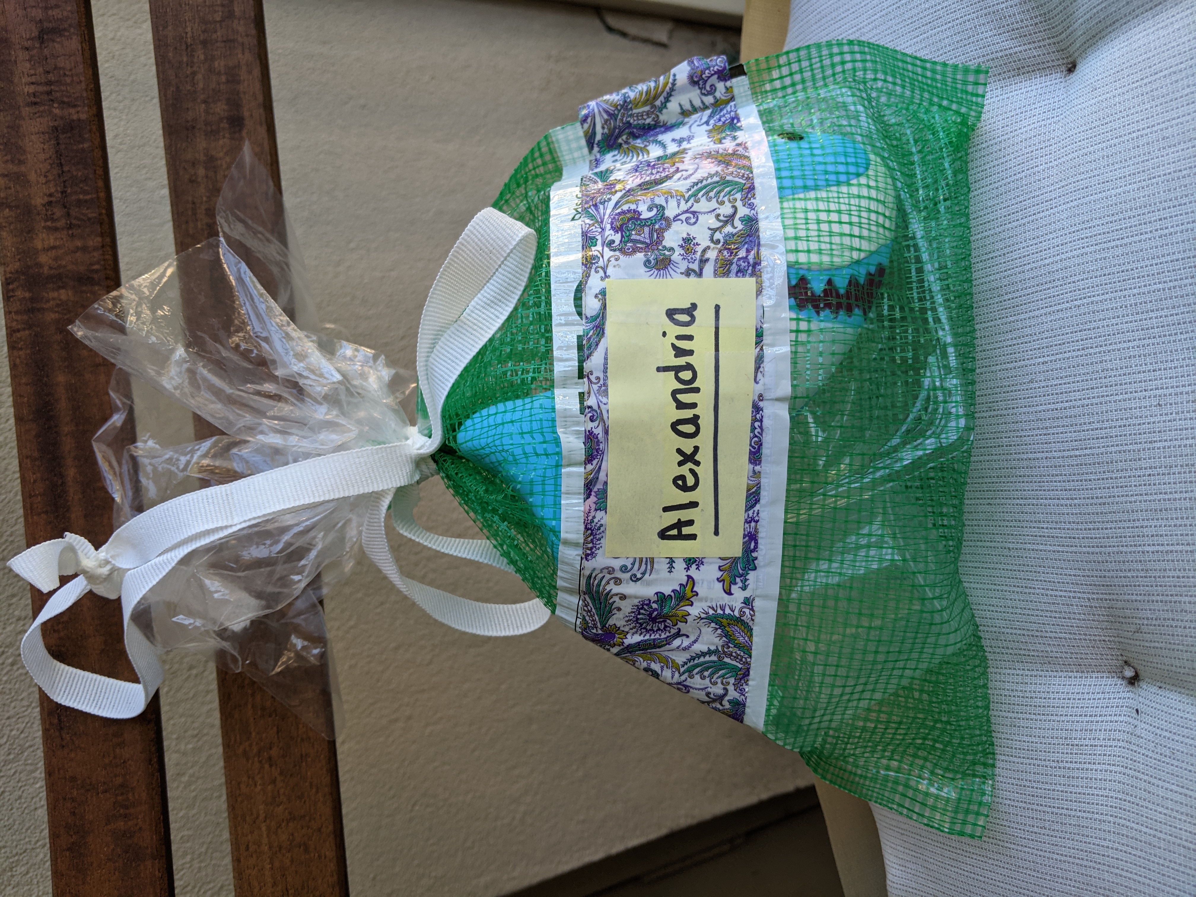 A repurposed mesh produce bag full of upcycled beach toys from plastic containers.