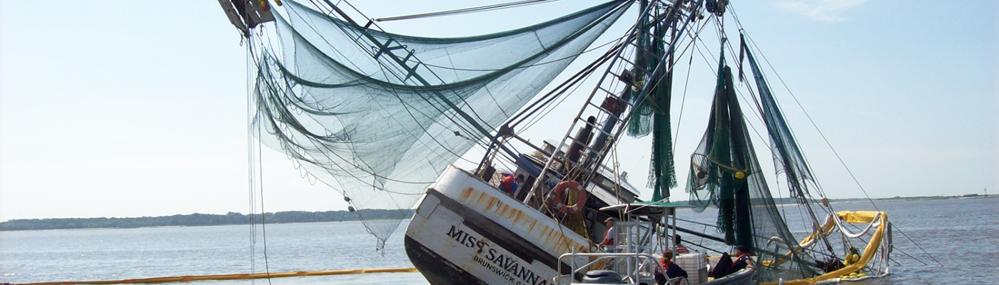 Derelict sailboat with containment boom.