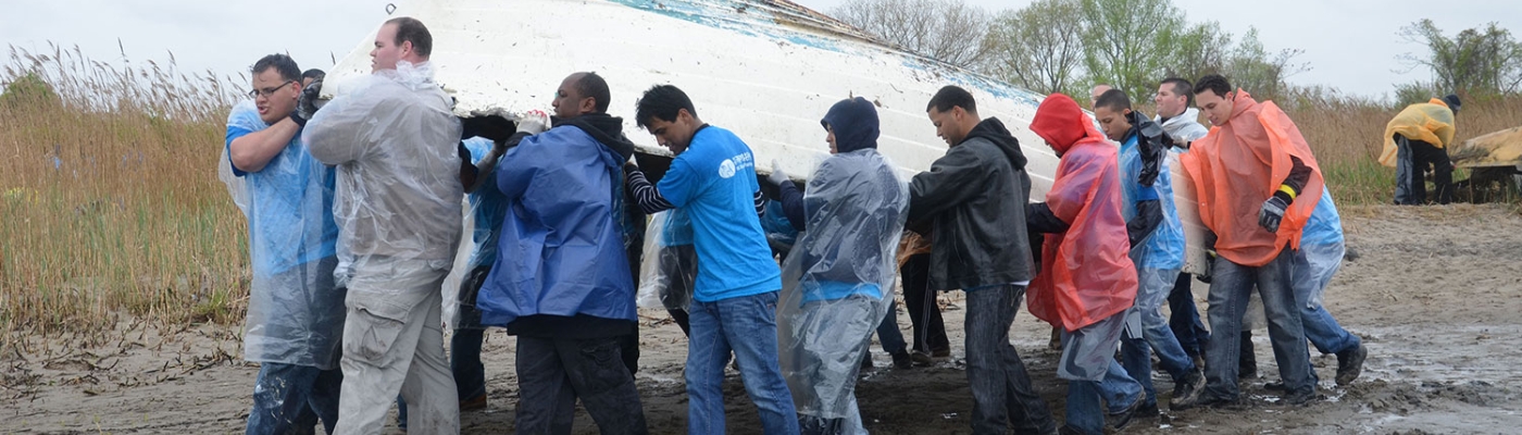 Volunteers removing a derelict vessel from a shoreline in New York