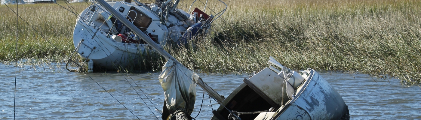 Two abandoned and derelict vessels in a salt marsh.