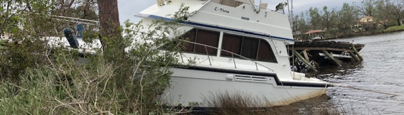 A derelict vessel grounded on the shore.
