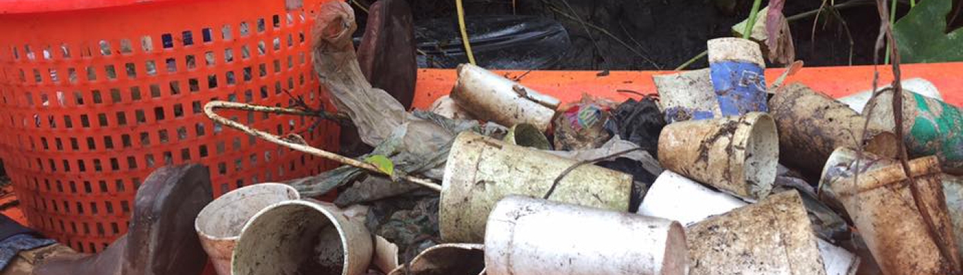 Trash piled in an orange kayak that was collected from a river cleanup.