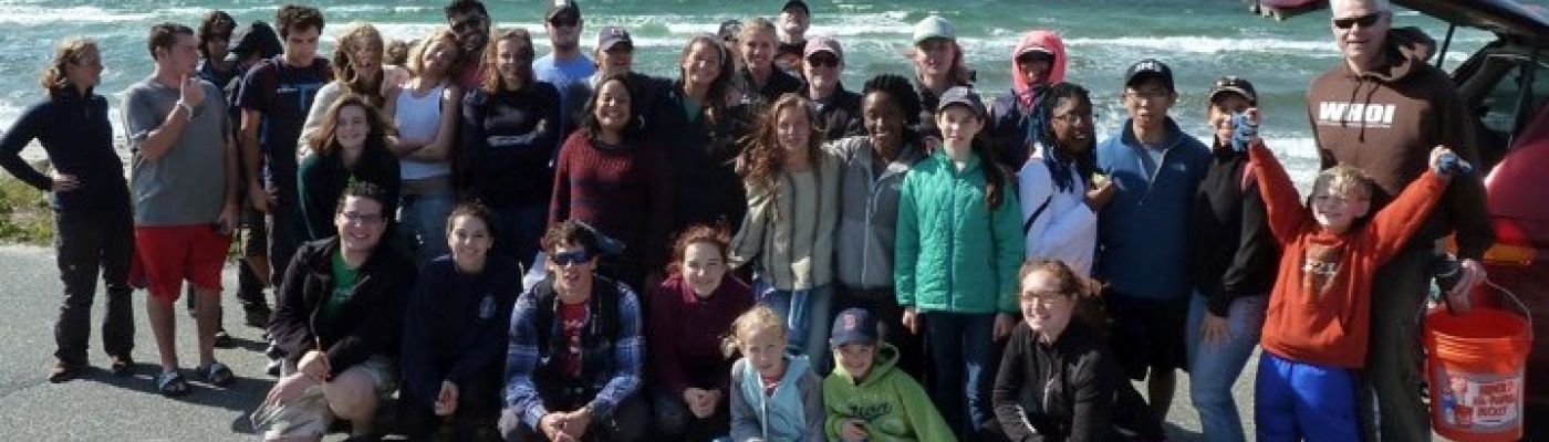 A cleanup group posing in front of a beach.