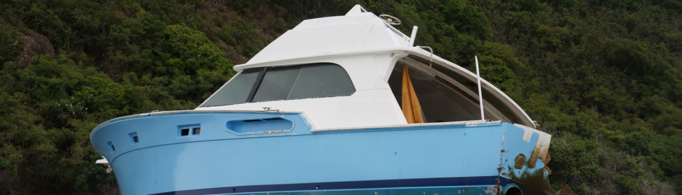 An abandoned derelict vessel on the coastline.