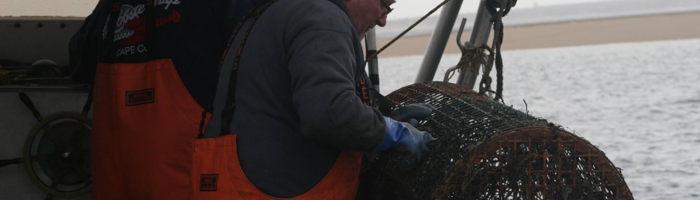 Lobstermen pulling a derelict trap out of the water.