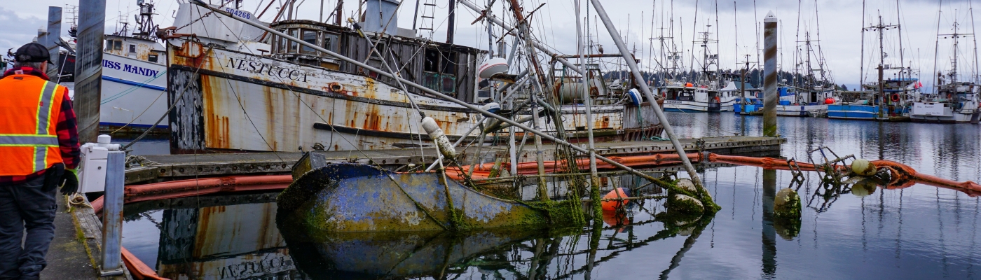 An abandoned and derelict vessel submerged in a marina.