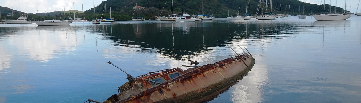 A derelict vessel is partially submerged in Coral Bay. 