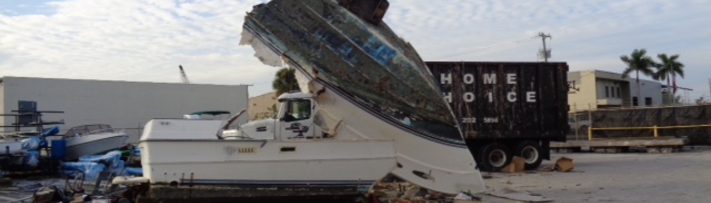 Derelict vessel being crushed at a landfill yard. 