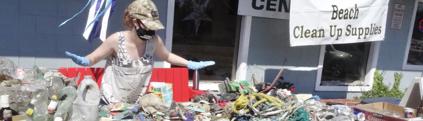 A person with gloves at a table covered in collected marine debris.
