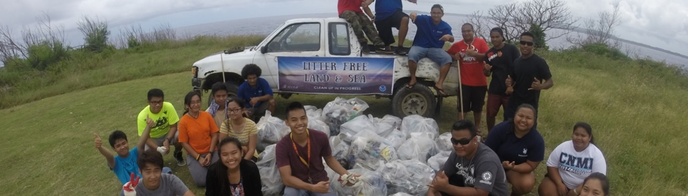 Participants pose with their haul from a beach cleanup as part of the Micronesia Island Nature Alliance’s efforts against marine debris.