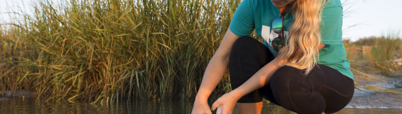 A citizen scientists collects water samples.