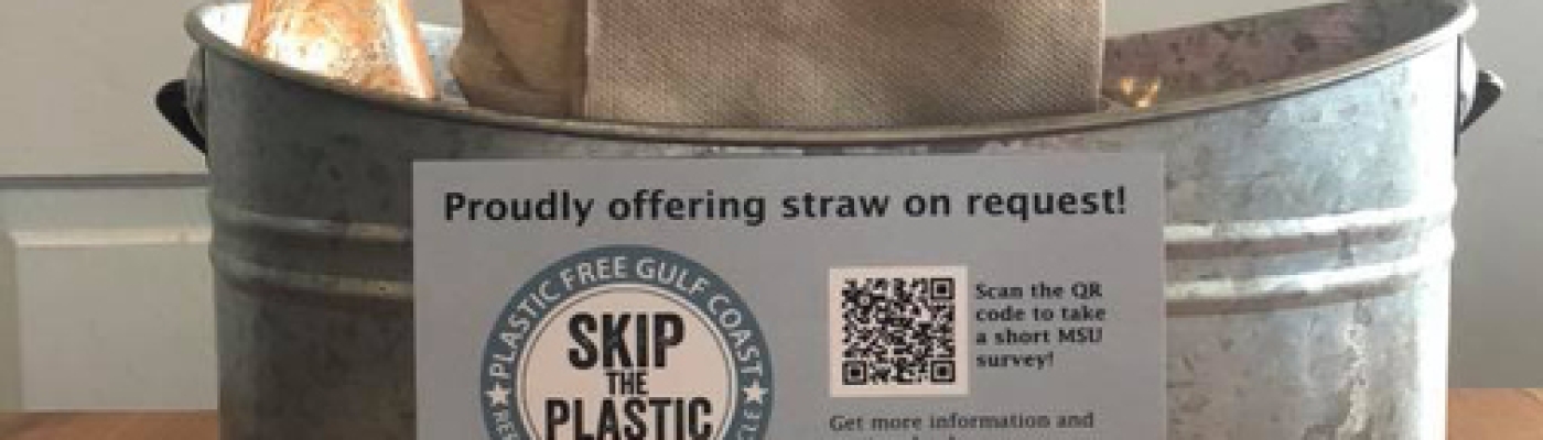 Napkin bin with sign about plastic free gulf coast. 