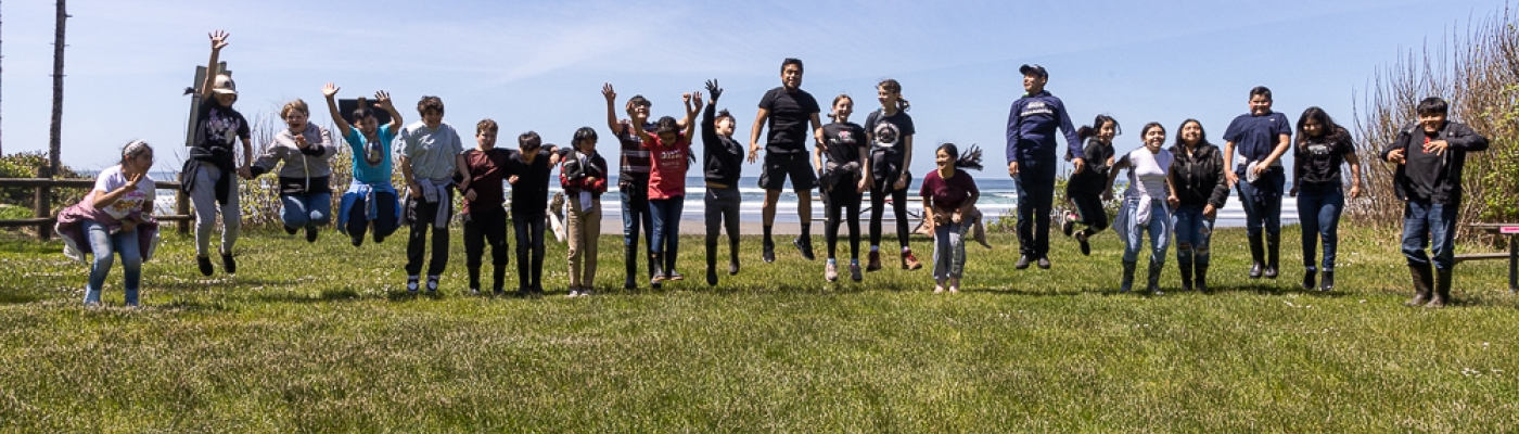 Large group of students on a grassy slope.