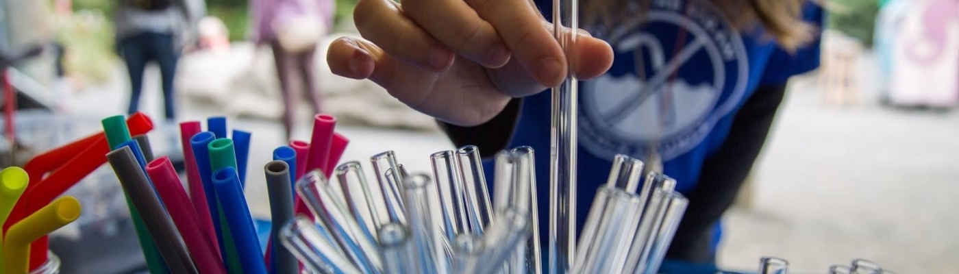 A child picks up a glass straw. 