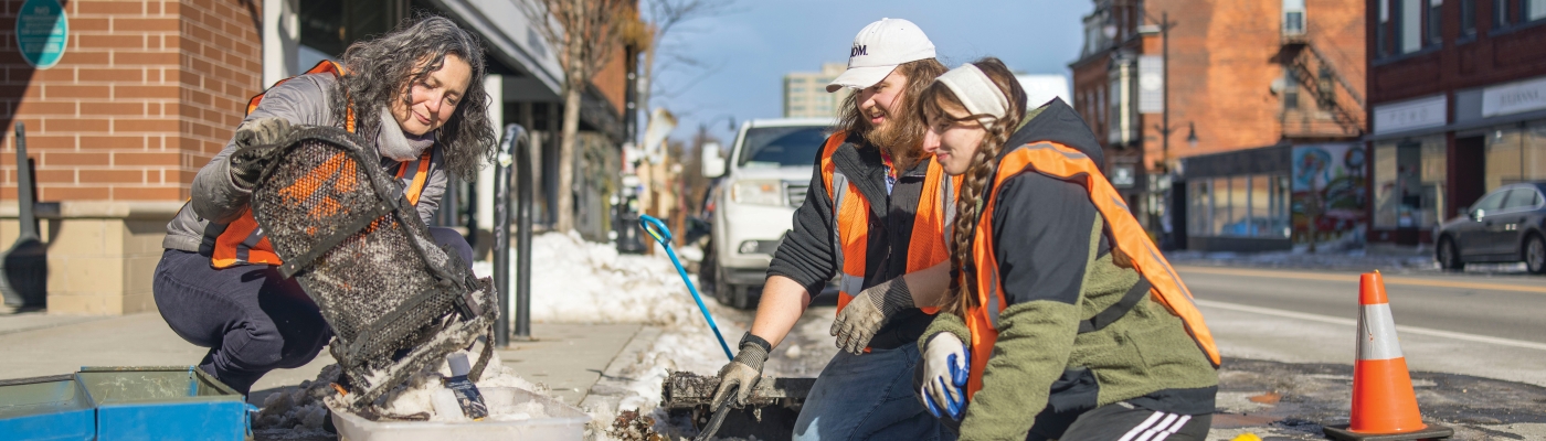 Volunteers cleaning debris out of a storm drain.