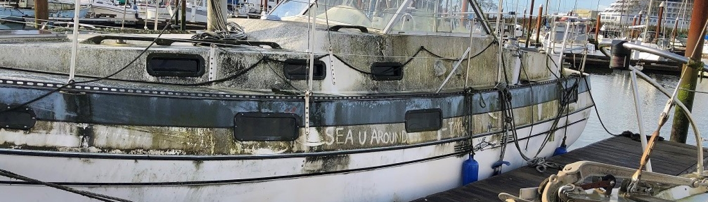 A derelict vessel tied to a dock.