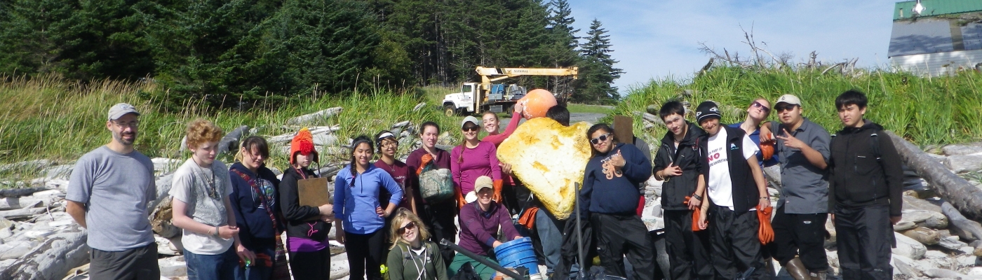 Students gather around several bags of trash. 