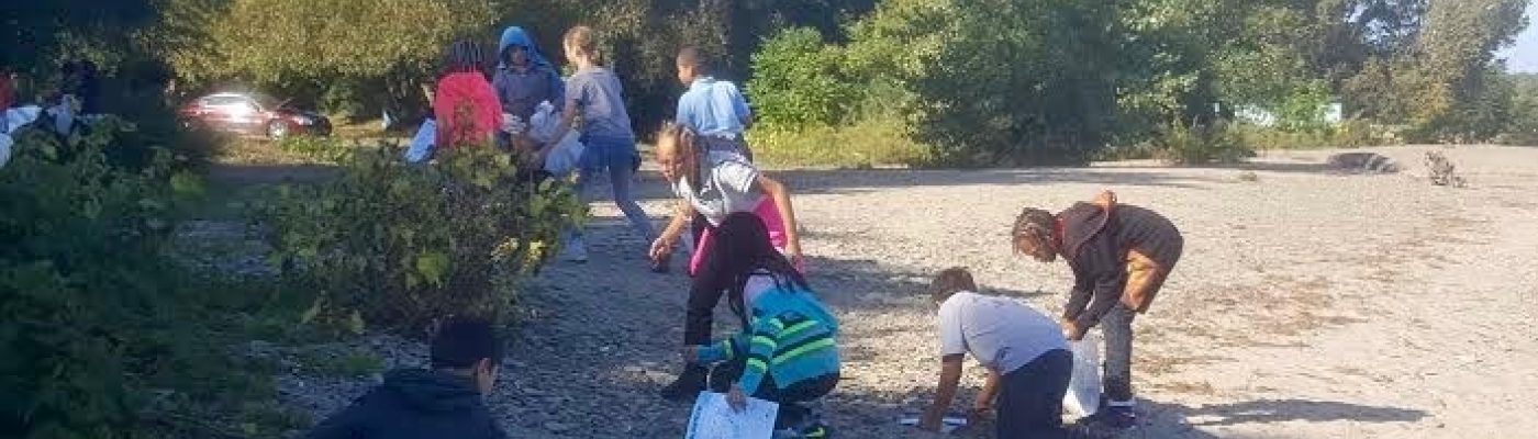 Students cleaning up debris on a beach.