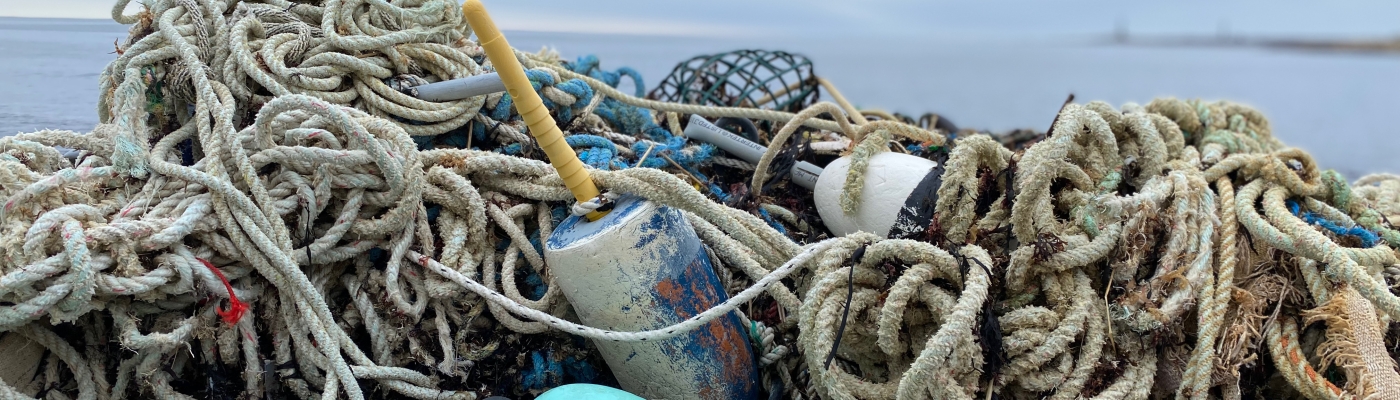 A pile of old rope and fishing gear on a shore.