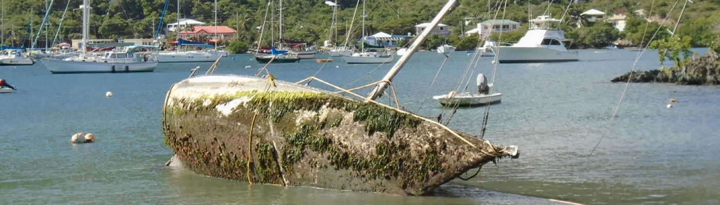 A overturned derelict vessel in a harbor.