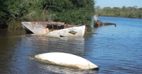 Derelict vessels partially-submerged in water.