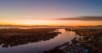 An aerial view of a waterway through an urban area at sunset.