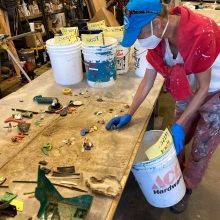 A volunteer sorts marine debris at a table.