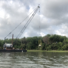 A sailboat, left in the wake of Hurricane Irma, being lifted out of the marsh and maritime forest edge in Charleston Harbor. 