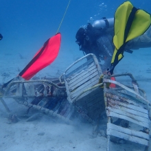 Divers attach lift bags to remove marine debris, including lawn chairs and galvanized metal, from Coki Beach, U.S. Virgin Islands.