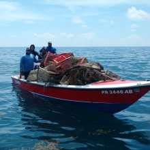 A dive crew transporting derelict fishing gear back to shore after a removal expedition. 