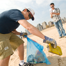 A volunteer cleaning up debris along a beach.