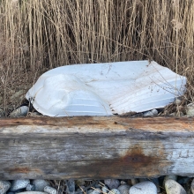 A small overturned boat on a rocky shore