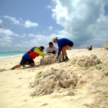 The Marine Debris team cutting the large bundle of thin plastic film into manageable pieces. (NOAA PIFSC Coral Reef Ecosystem Program)