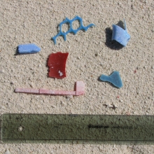 Assorted hard plastic fragments found on a beach.