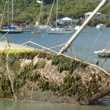 A overturned derelict vessel in a harbor.