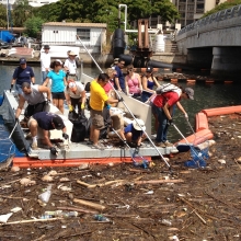 ICC volunteers scoop marine debris out of a trash boom in Honolulu. 