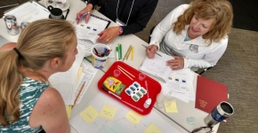 People sitting at desk with multiple activities.