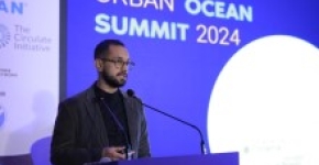 A speaker making opening remarks at the Urban Ocean Summit stage.