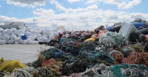A pile of debris sits on a large barge surface. 