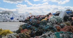 A pile of debris sits on a large barge surface. 