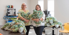 Two women holding stuffed turtles