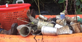 Trash piled in an orange kayak that was collected from a river cleanup.
