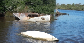 Derelict vessels partially-submerged in water.