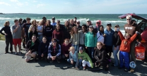 A cleanup group posing in front of a beach.