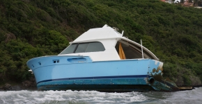 An abandoned derelict vessel on the coastline.