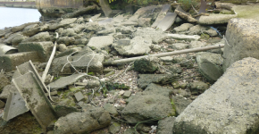 Ropes and other debris scattered along a rocky shore. 