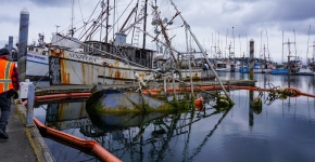 An abandoned and derelict vessel submerged in a marina.