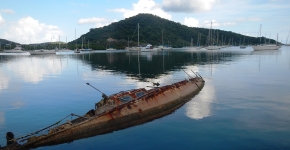 A derelict vessel is partially submerged in Coral Bay. 