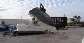 Derelict vessel being crushed at a landfill yard. 